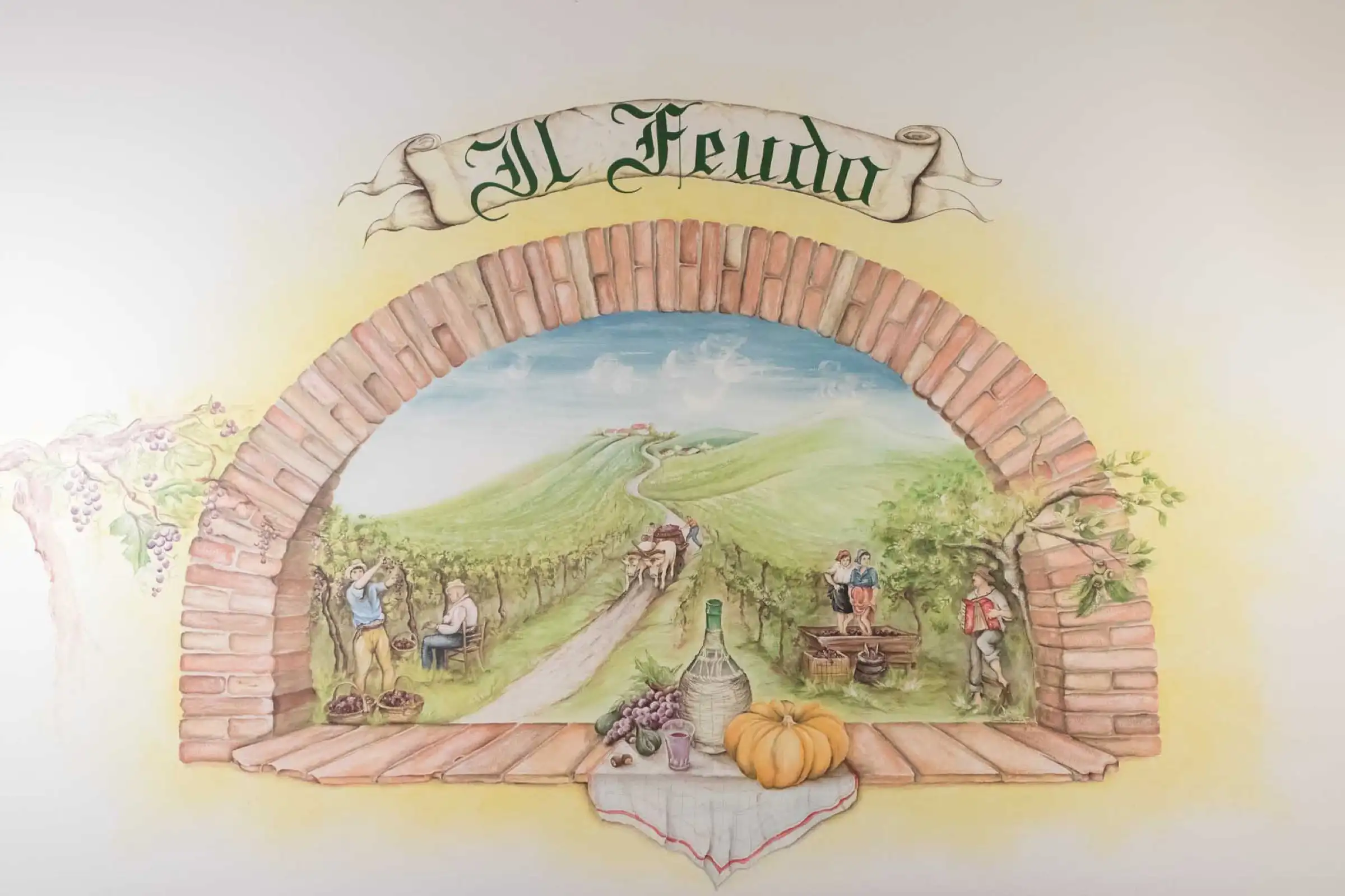 The dining-room fresco: a grape harvest in the hills framed by a brick arch, with the name Il Feudo