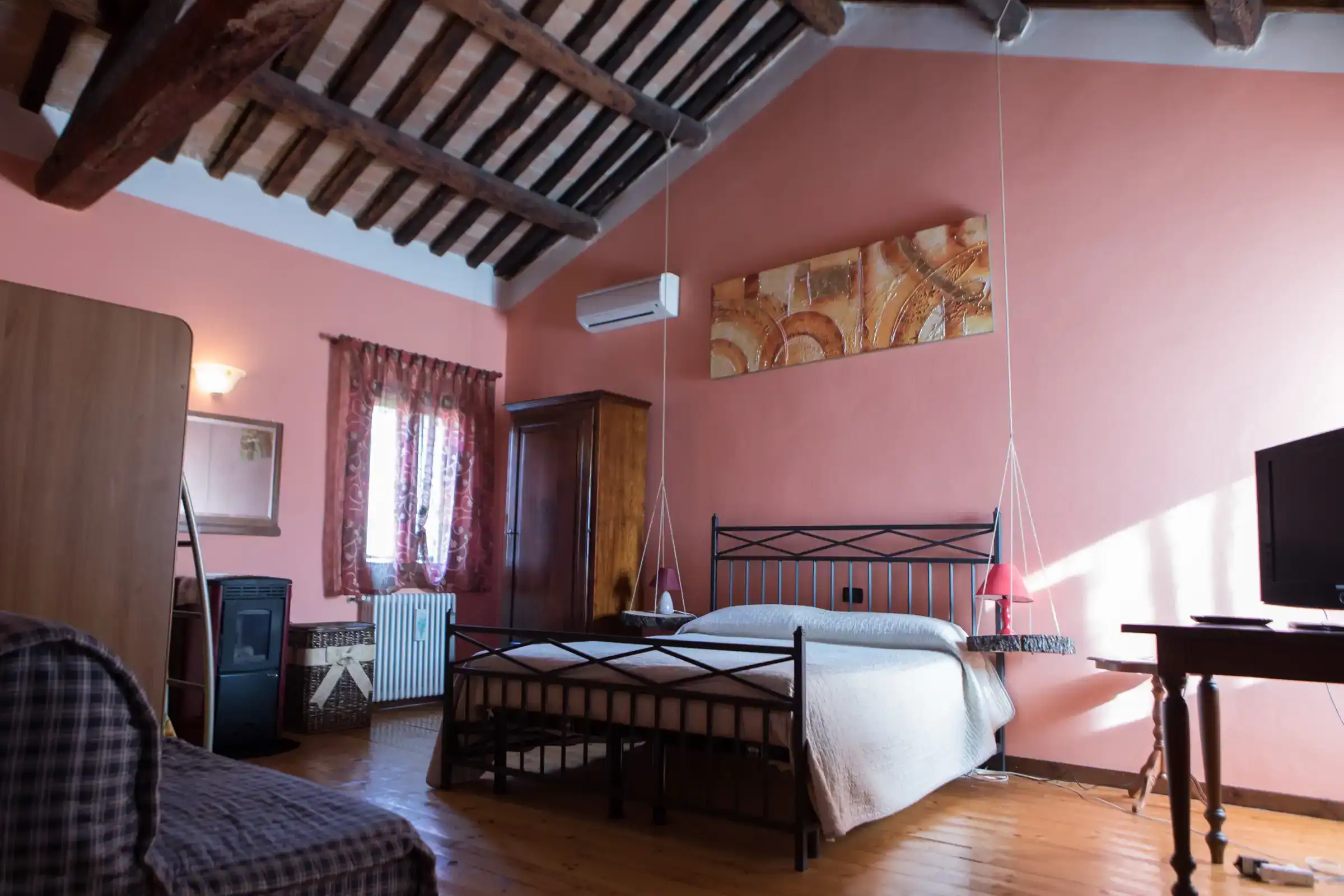 Double room with exposed beams, wrought-iron bed and wooden floor